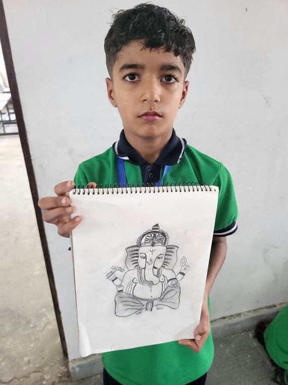 A student of Janhit World School showing his pencil sketch at the art competition