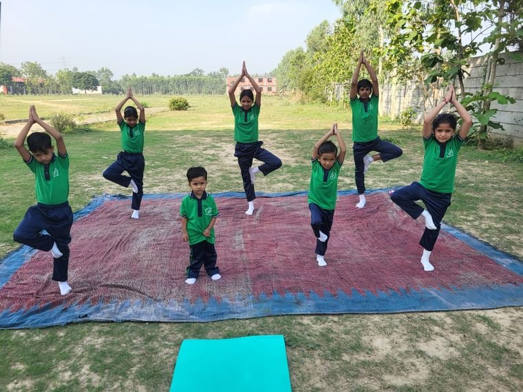 Students practising the tree pose during a yoga session on the school ground, Janhit World School