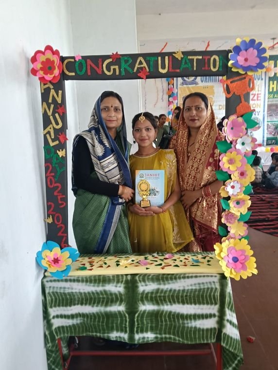 A student with her teacher and family at the prize ceremony photo booth, Janhit World School