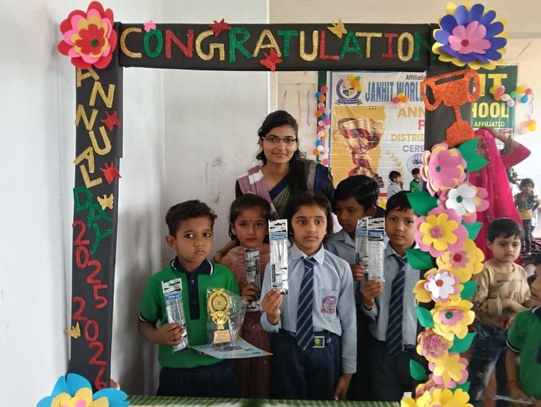Junior students showing their prizes with a teacher at Janhit World School